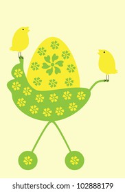 Yellow egg decorated with green flowers in pram and two cute birds sitting on it