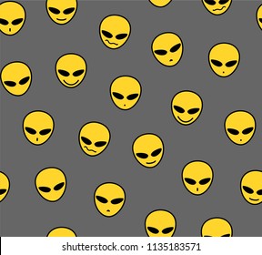 Yellow faces of aliens on a gray field.  