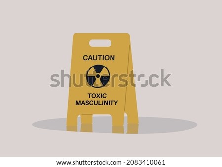 A yellow floor sign warning about toxic masculinity, the idea of manliness as being defined by domination, homophobia, and aggression