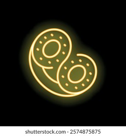 Yellow glowing neon sign representing two slices of kiwi fruit, isolated over a black background