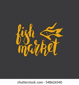 Yellow hand written with brush pen and inc inscription fish market, lettering, calligraphy with fish silhouette on black background. Vector. Could be used for fish restaurant, market.