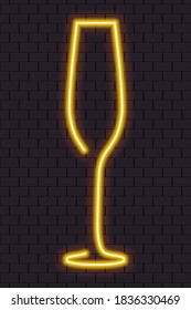 Yellow neon champagne glass for banner or sign isolated on a dark brick wall.