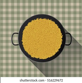 Yellow rice in paella pan on tablecloth