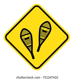 yellow sign for snowshoeing route. old style traditional snowshoes. winter outdoor activity.