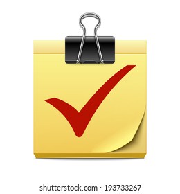 Yellow sticky note paper with red check mark and binder clip