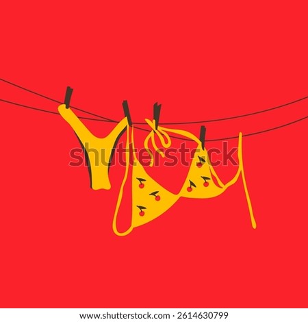 A yellow swimsuit with a playful cherry pattern hanging on a clothesline under the sun.
