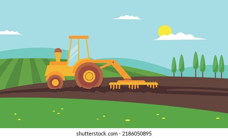 yellow tractor plows in the field
