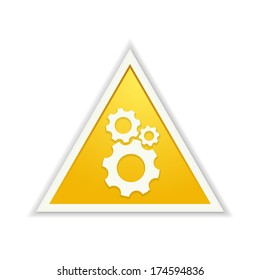 The yellow triangle button with the setting symbol / the glossy setting triangle / the cogwheel icon