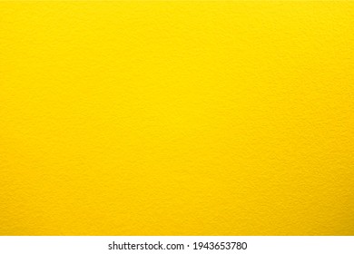 Yellow wall in spots, cracks, stains. Painted concrete wall in abstract grunge style. Grunge background texture for backgrounds, portraits, posters.