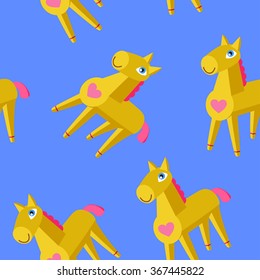 Yellow wooden toy horses on blue seamless pattern