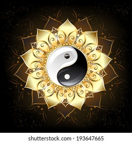 Yin yang symbol, drawn in middle of lotus with golden petals on black background.