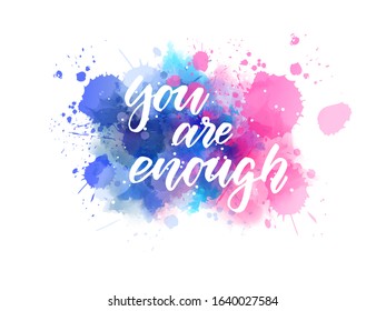 You are enough - motivational message. Handwritten modern calligraphy inspirational text on blue and pink colored watercolor paint splash.