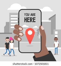 You are here. Navigation in the city. Black hand holding a mobile phone. Technologies. Flat editable vector illustration, clip art