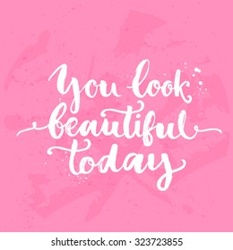 You look beautiful today. Inspirational quote, white brush calligraphy handwritten on pink background. Vector lettering for card and poster design, social media content and fashion.