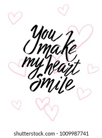 You make my heart smile Valentines day calligraphy card. Hand drawn design elements. Handwritten modern brush lettering.
