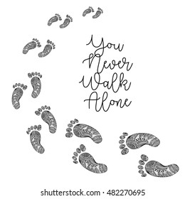 "You never walk alone " handwritten with footprints in decorative style.