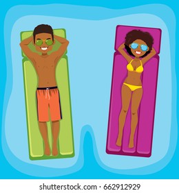 Young African American couple enjoying relaxing time floating with inflatable on swimming pool