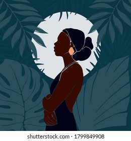 Young African American woman stands in profile against the background of the moon. Night in the jungle. Large tropical leaves. Dark blue vector illustration in flat style.