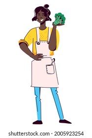 Young African American woman in sweater and apron stands in a confident position and holds a broccoli in her hand. Concept of healthy food, cooking. Vector illustration isolated on white background.