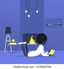 Young african female character lying on a floor next to a fireplace and reading a book, modern living room interior