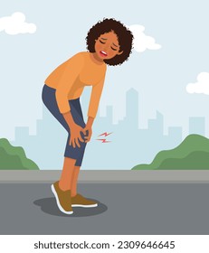 Young African woman suffering from knee pain when exercising in the park