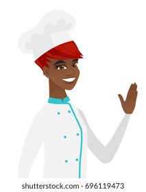 Young african-american chef cook waving her hand. Chef cook making greeting gesture - waving hand. Vector flat design illustration isolated on white background.