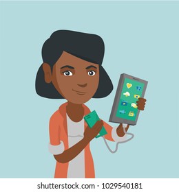 Young african-american woman recharging her smartphone with a mobile phone portable battery. Smiling woman holding a mobile phone and a battery power bank. Vector cartoon illustration. Square layout.