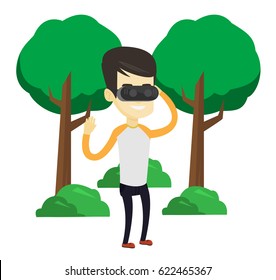 Young asian gamer wearing virtual reality headset in the park. Happy man using virtual reality glasses and playing videogame in the park. Vector flat design illustration isolated on white background.