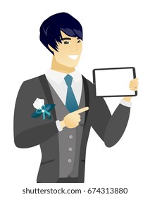 Young asian groom holding a tablet computer. Smiling groom pointing at a tablet computer. Happy groom with a tablet computer. Vector flat design illustration isolated on white background.