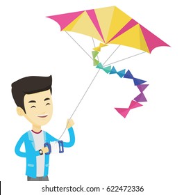 Young asian man flying a colourful kite. Smiling man controlling a kite. Happy man walking with a kite. Cheerful man playing with a kite. Vector flat design illustration isolated on white background.
