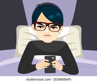 Young Asian man suffering smartphone addiction sleepless on bed at night