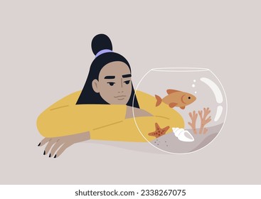 A young Asian person watching a goldfish swimming in a round water tank