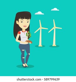 Joven asiático sonriente trabajador de un parque eólico. Mujer sosteniendo en las manos una pequeña planta verde en el suelo sobre el fondo de las turbinas eólicas. Concepto de energía verde. Ilustración de diseño plana vectorial. Diseño cuadrado.