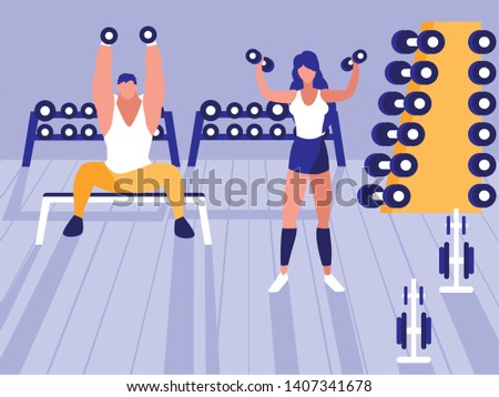 young athletic couple lifting dumbbells in gym