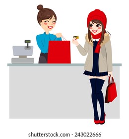 Young beautiful brunette woman paying purchase with credit card while store clerk is preparing shopping bag