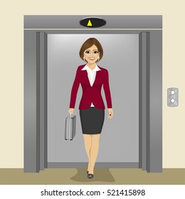 young beautiful businesswoman with briefcase coming out of office building elevator