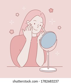  A young beautiful girl in front of a mirror takes care of her skin.The girl does makeup in front of the mirror. Touches the face. Hand drawn style vector design illustration. 