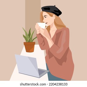 Una joven y hermosa chica se sienta en un café con una taza de café o té en sus manos. Una mujer rubia con un sombrero toma y una chaqueta Toma una bebida caliente y trabaja desde un café. Un ordenador portátil con plantas