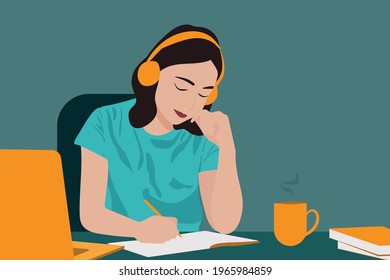 Young beautiful student girl listening to online courses in headphones at home, online studying concept