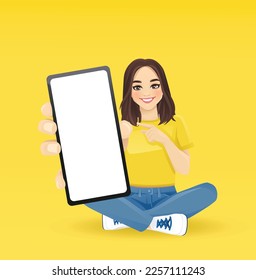Young beautiful surprised woman pointing to the blank phone screen sitting in lotus pose with crossed legs isolated vector illustration