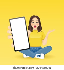 Young beautiful surprised woman showing blank phone screen sitting in lotus pose with crossed legs isolated vector illustration