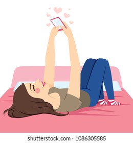 Young beautiful teenager girl lying on bed using pink smartphone