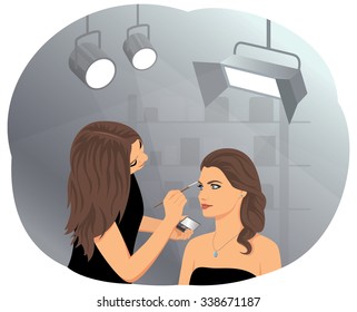 Young beautiful woman applying makeup by makeup artist in the studio. Fashion and cosmetic.