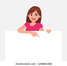 Young beautiful woman smiling and holding a blank / empty sheet of white paper or board and pointing with index finger. Human emotion & body language concept illustration in vector cartoon flat style.