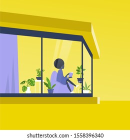 Young black female character reading a book in front of the window inside a modern house, outside view