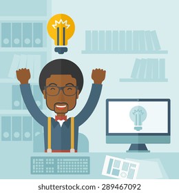 A young black guy is happy raising his two hands getting an idea through computer internet inside his office. Successful concept. A Contemporary style with pastel palette, soft blue tinted background