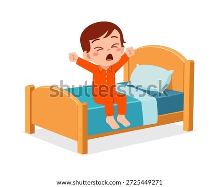 A young boy in orange pajamas sitting on his bed stretching and yawning happily while waking up