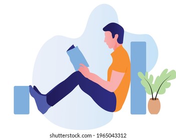 A young boy is reading a book on the floor