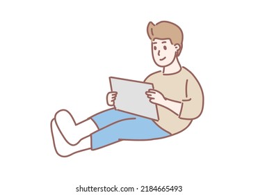 Young boy sitting on  floor at home holding  tablet illustrator cartoon vector