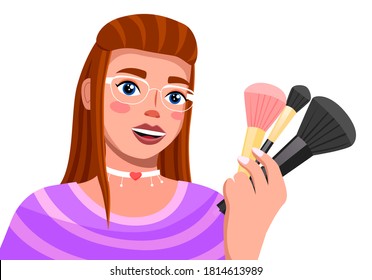 Young brown haired girl in glamour glasses talks about make-up brushes. Modern trendy girl with cosmetic accessories in hand. Woman with fashionable make-up and a choker on her neck. Blooger, streamer